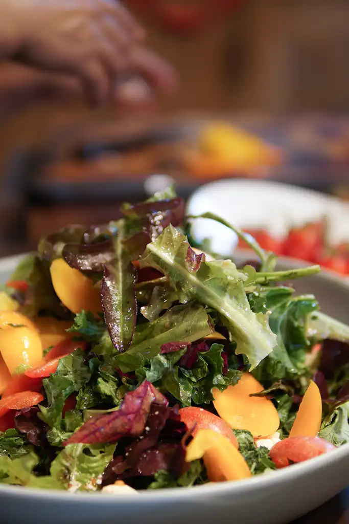 woman-preparing-cooking-making-vegetable-salad-in-2023-11-27 Fresh seasonal salad prepared in the Rose & Crown kitchen