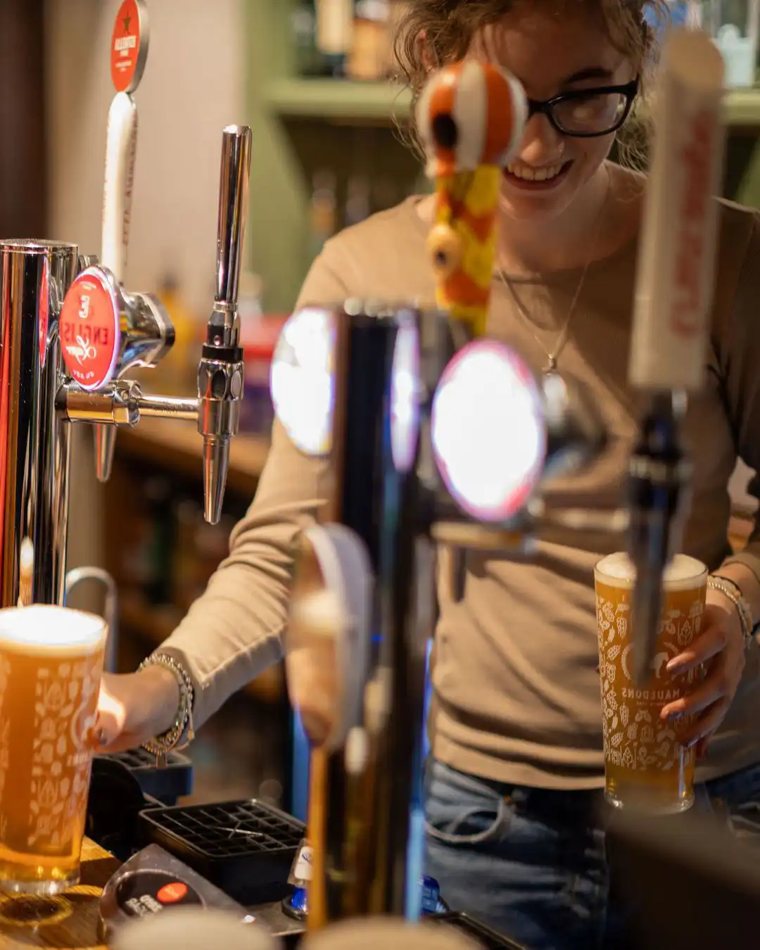 Join our team at the Rose & Crown in Ashdon Bar team member at the Rose & Crown, Ashdon, smiling as she pours pints of beer at the bar